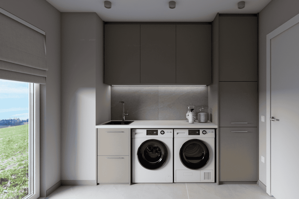 Modern and functional laundry room with built-in washing machine and cabinetry.