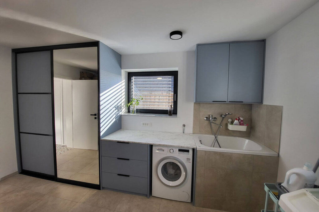 Custom bathroom cabinetry with washing machine and storage solutions.