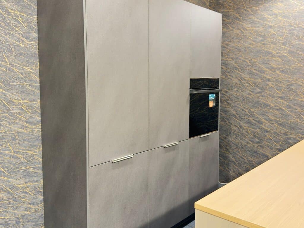 Modern grey kitchen cabinets with built-in oven and sleek design.